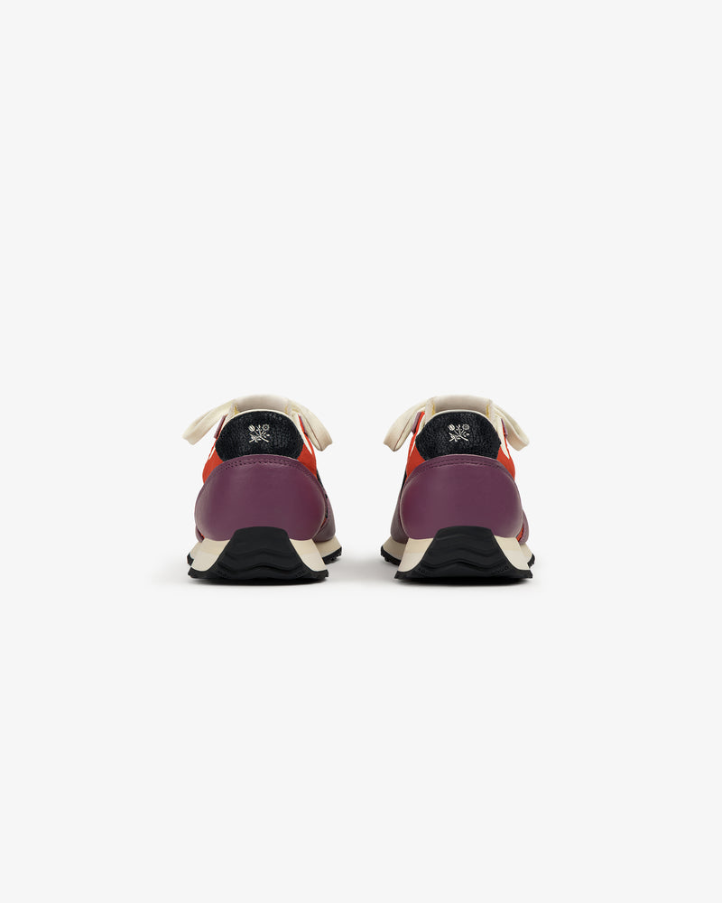 The ALD / New Balance 471 sneakers in purple and red, with white laces and black soles, shown from the back.