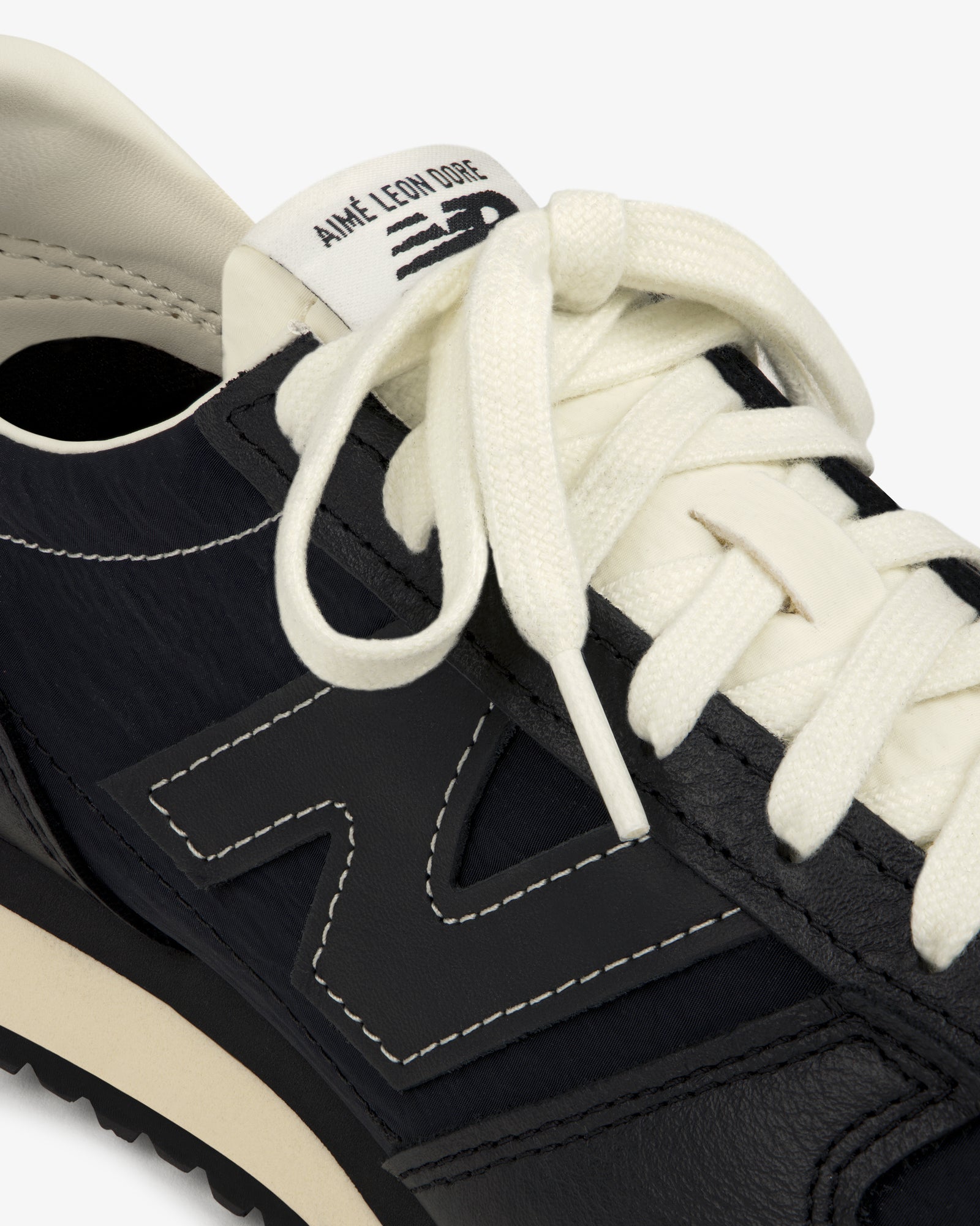 Close-up of a black ALD / New Balance 471 sneaker with white laces and branded tongue label.