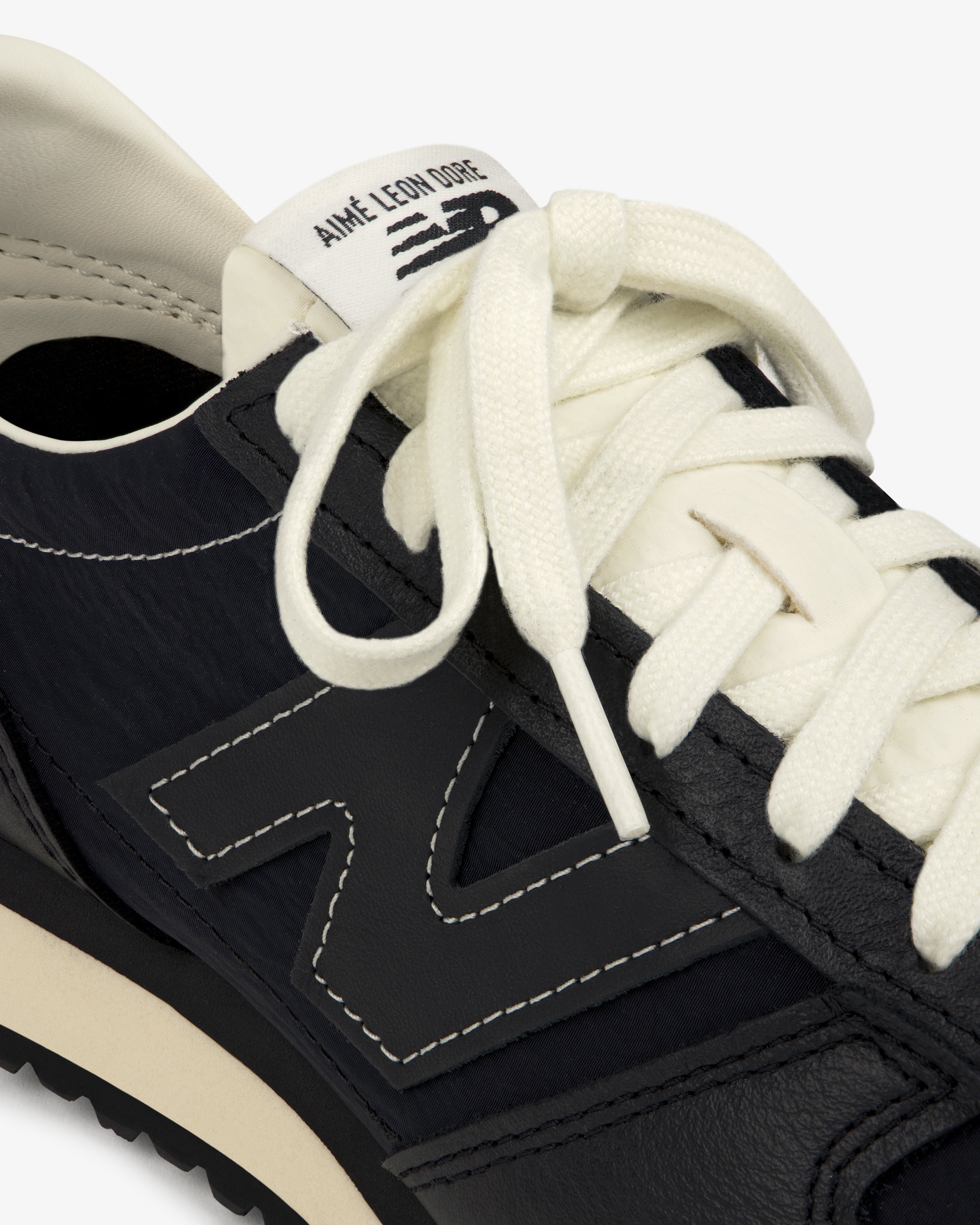 Close-up of a black ALD / New Balance 471 sneaker with white laces and branded tongue label.