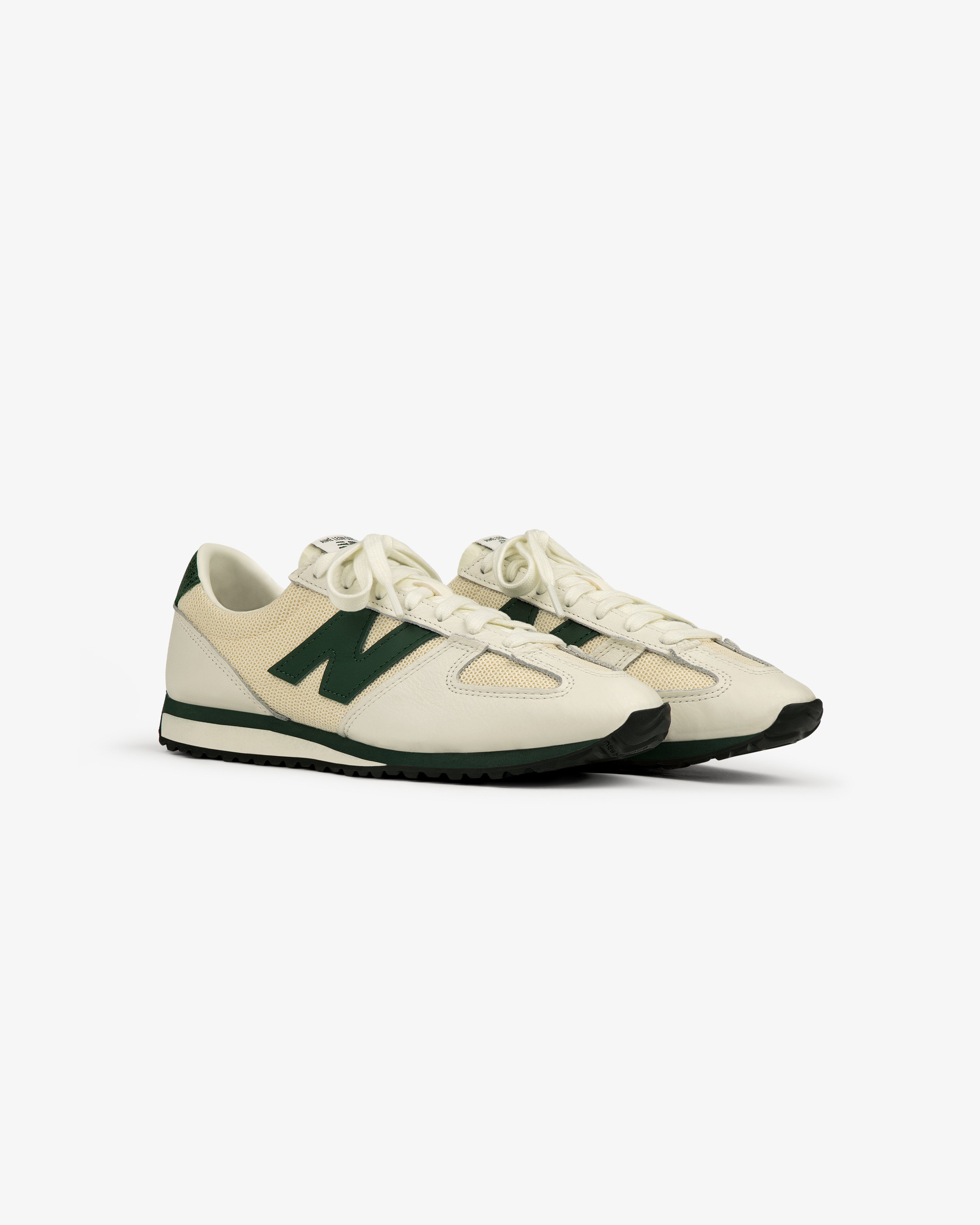 The ALD / New Balance 471 sneakers in cream with green accents, black soles, and laces on a white background.