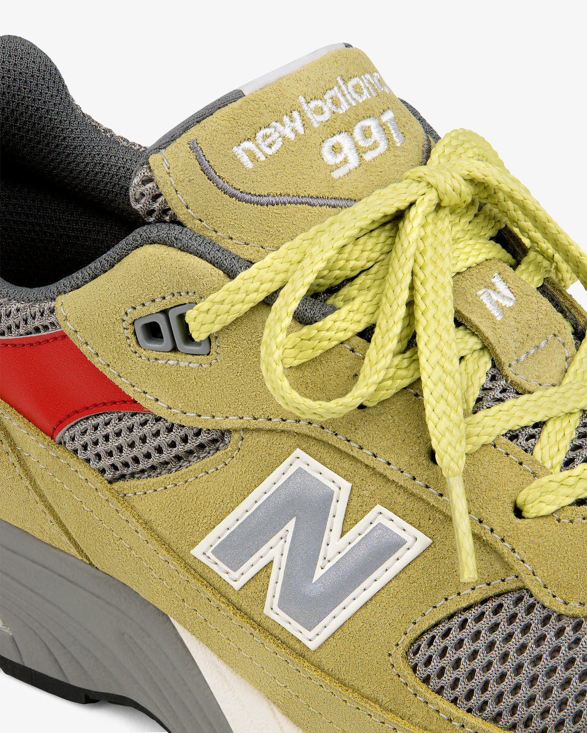 Close-up of ALD / New Balance Made in UK 991 in yellow suede with gray mesh, red accents, and yellow laces.