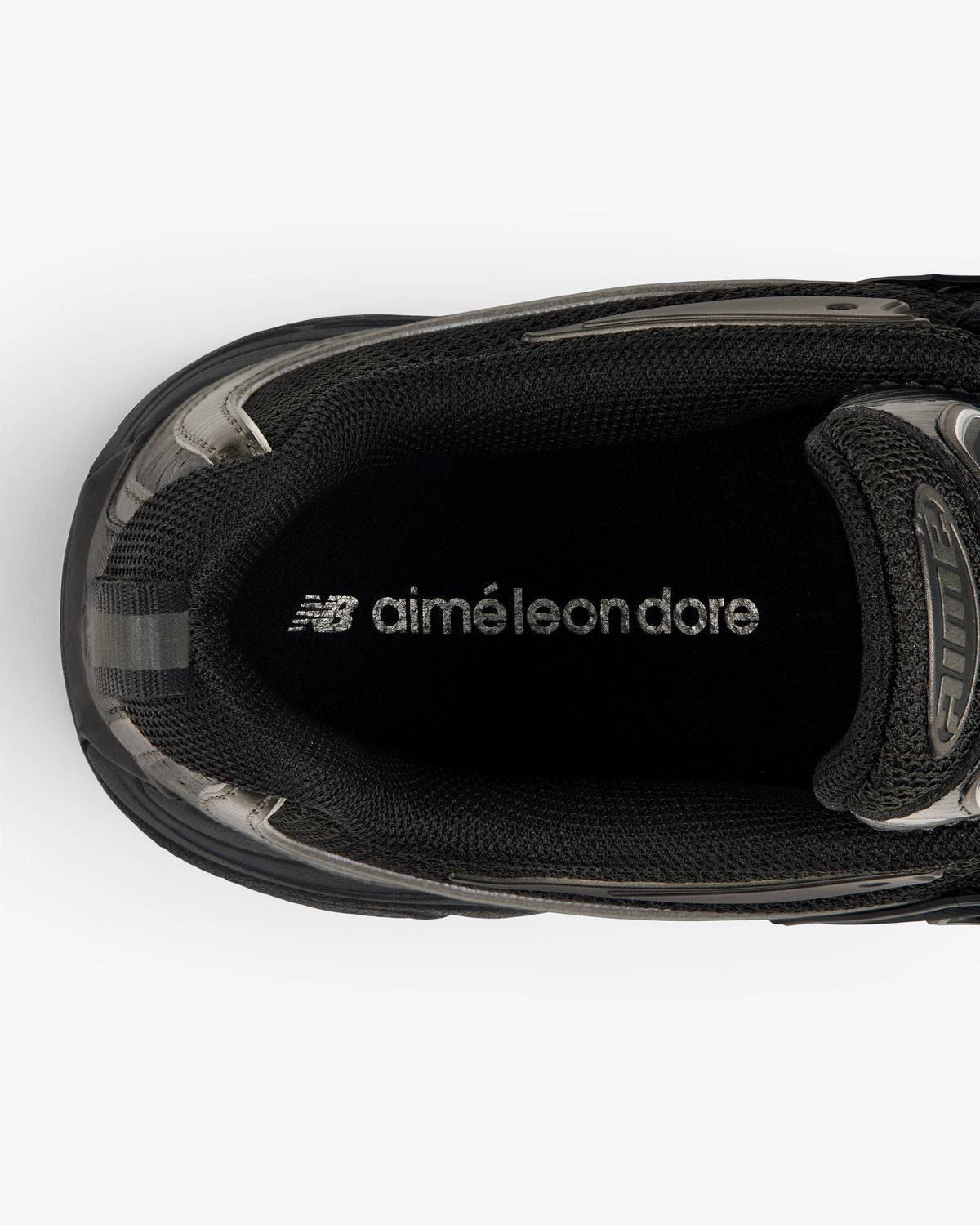 Top view of a black ALD / New Balance RC56 sneaker with "aimé leon dore" printed in white on the insole.
