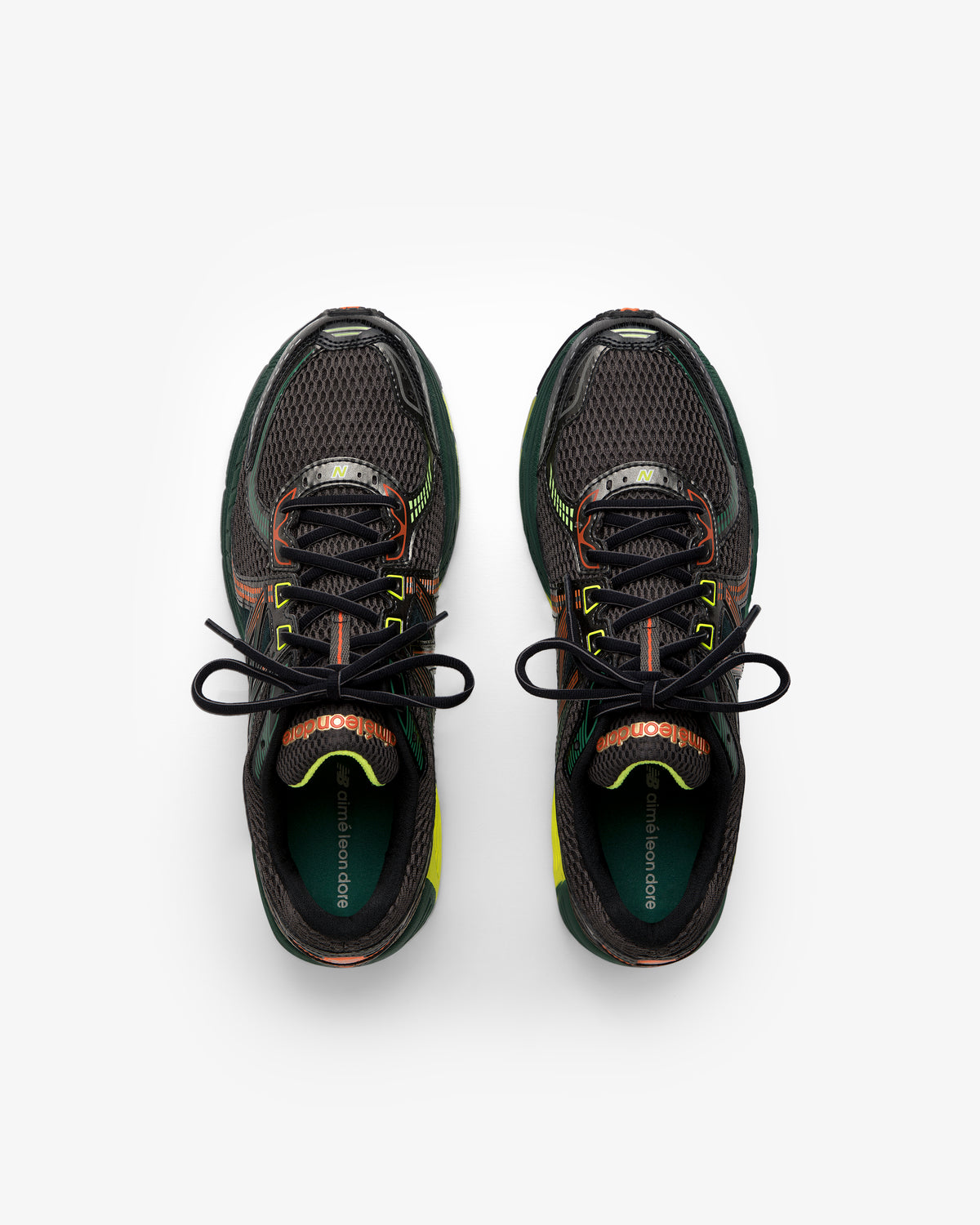 ALD / New Balance 860v2 black sneakers with green, orange, and yellow accents, top view on white background.