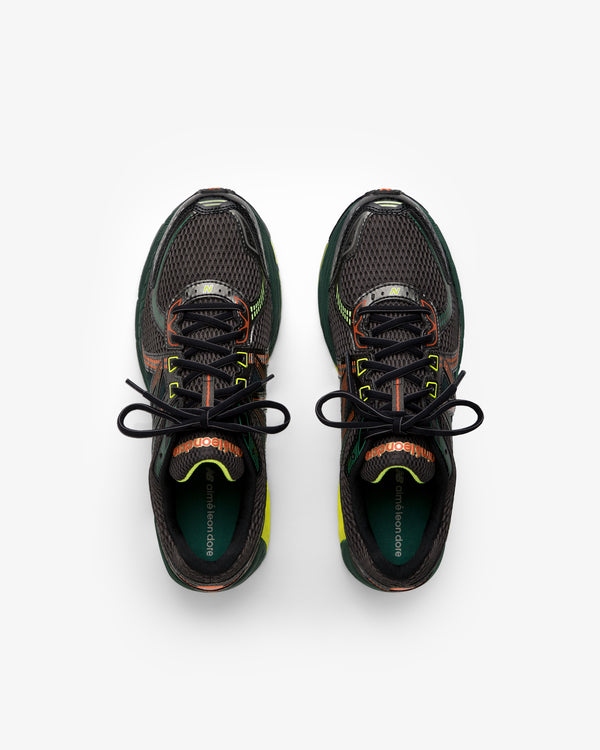 ALD / New Balance 860v2 black sneakers with green, orange, and yellow accents, top view on white background.