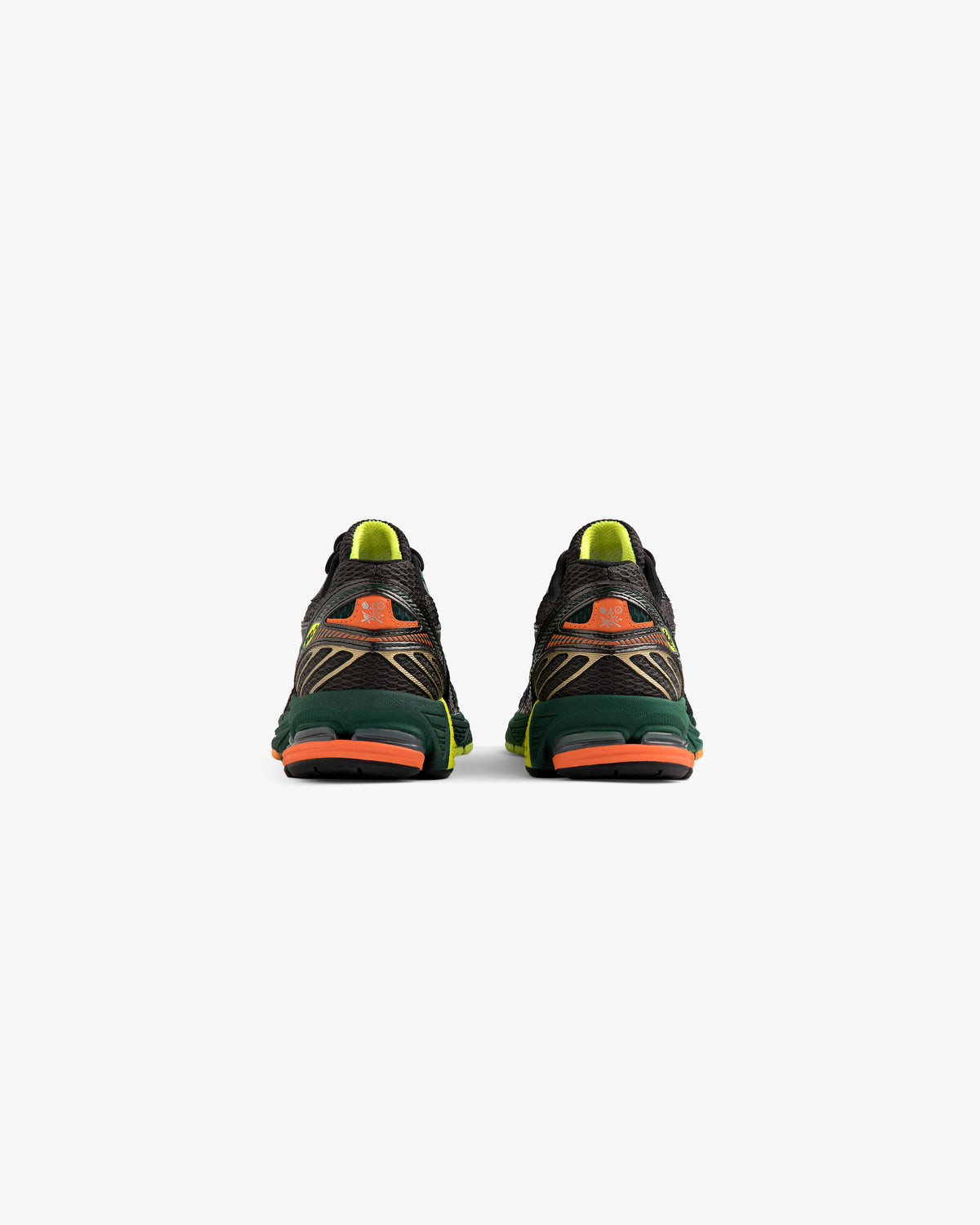 The ALD / New Balance 860v2 running shoes shown from the back have green, orange, and yellow accents on white.