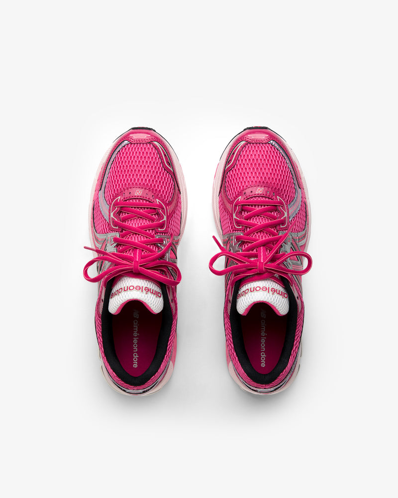 ALD / New Balance 860v2 pink running shoes with laces, top view on a white background.