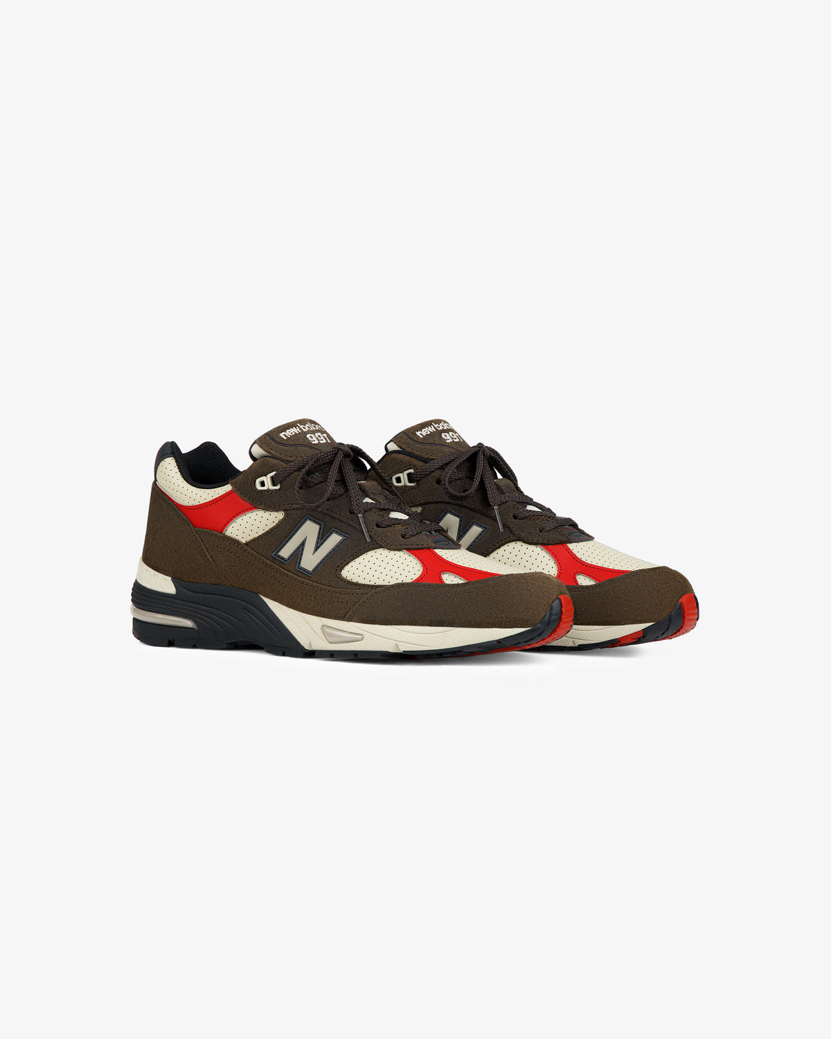 ALD / New Balance Made in UK 991 sneakers in brown, beige, red & black with white soles on a plain white background.