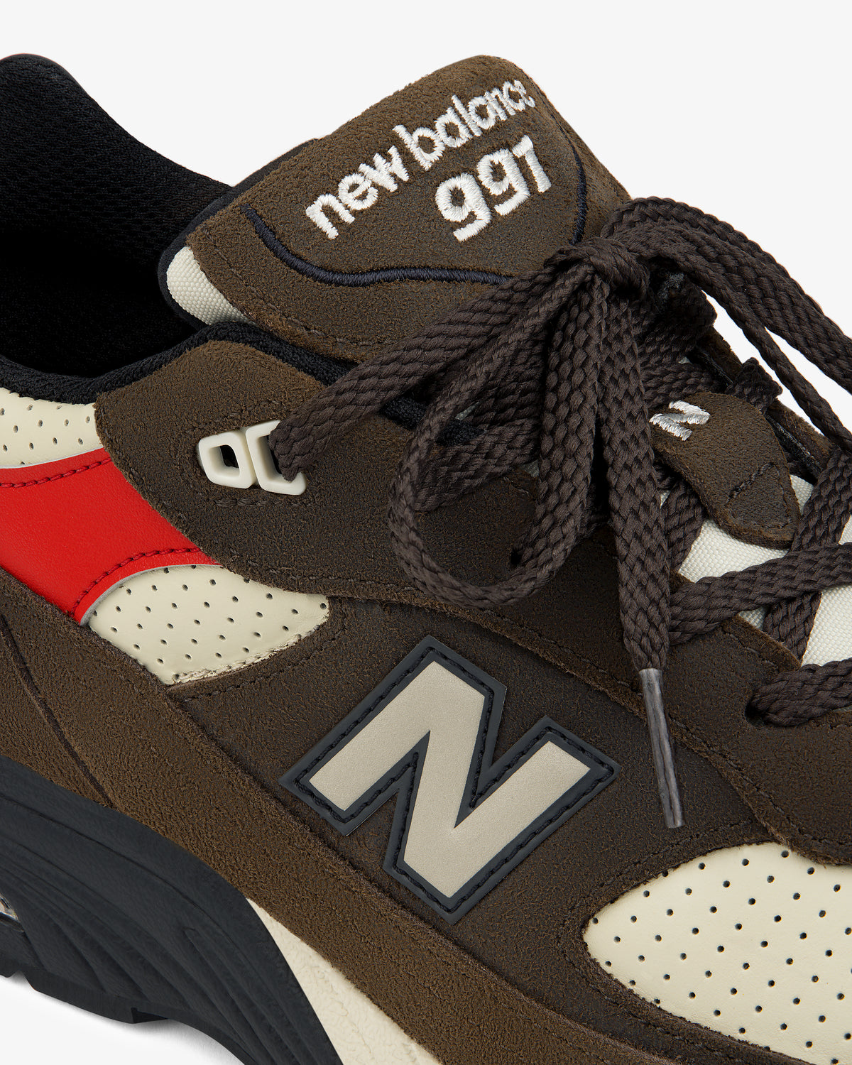 Close-up of a brown ALD / New Balance Made in UK 991 sneaker with red accent and visible logo on side and tongue.