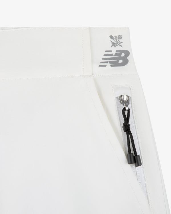 Close-up of ALD / New Balance RC56 Performance Nylon Trouser with zip pocket, NB logo, and snowflake-flower details.