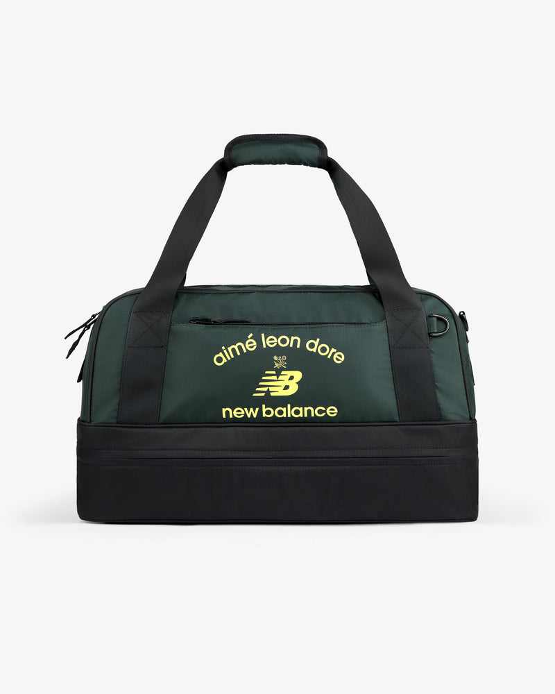 ALD / New Balance Travel Duffle Bag in dark green and black with yellow logos on the front.