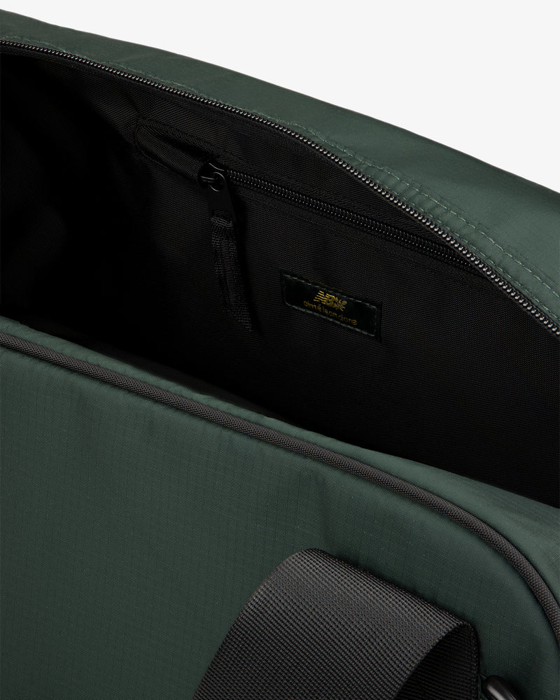 Close-up of ALD / New Balance Travel Duffle Bag open, showing black zippered inner pocket and inside label.