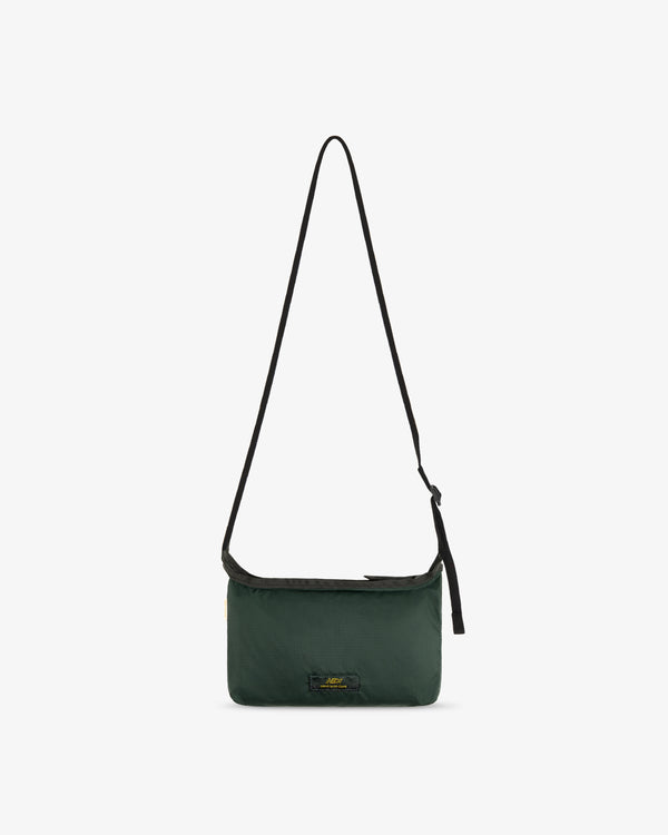 ALD / New Balance Nylon Sling Pouch, dark green with a long black strap and small front logo on white background.