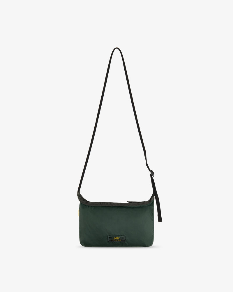 ALD / New Balance Nylon Sling Pouch, dark green with a long black strap and small front logo on white background.