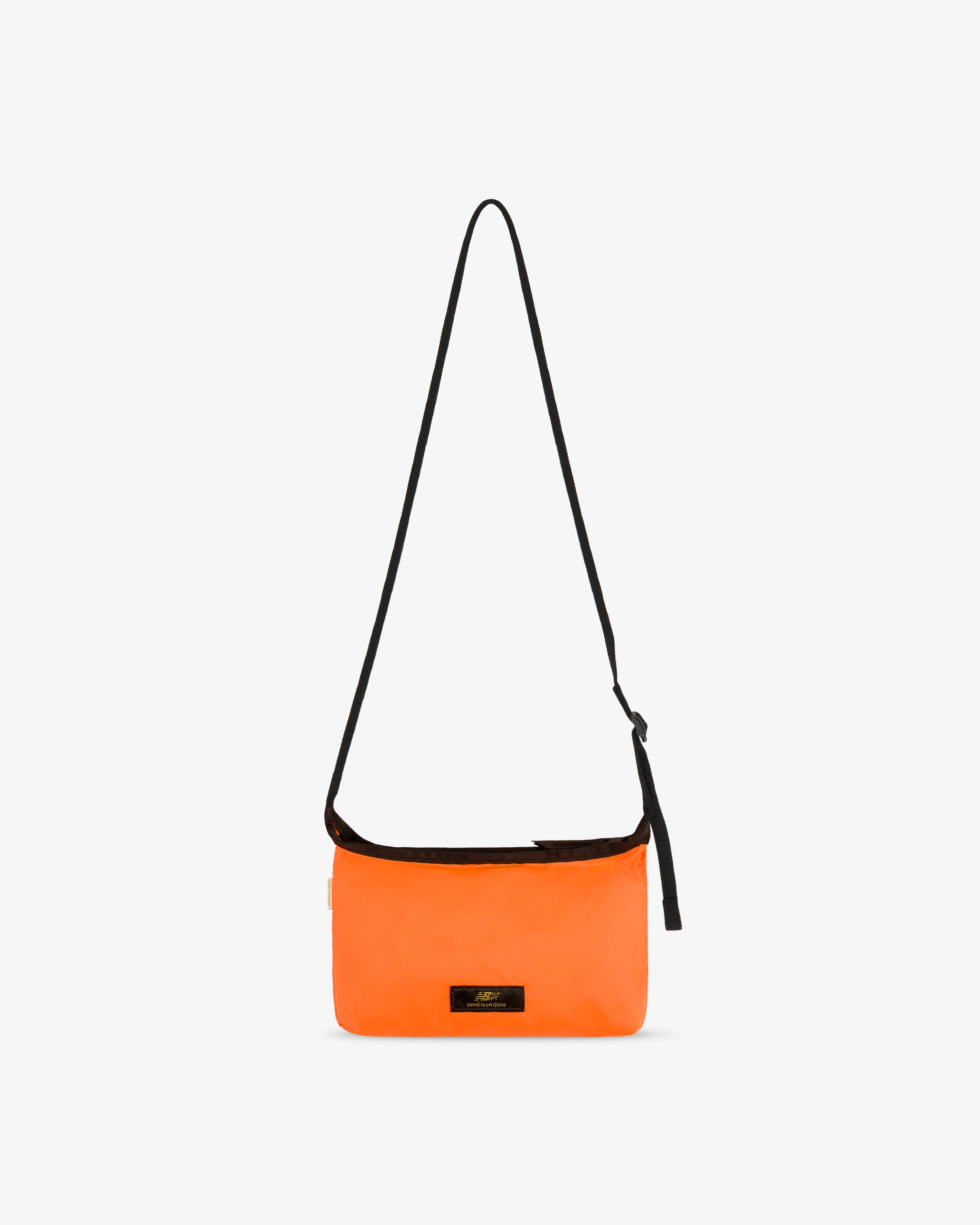 ALD / New Balance Nylon Sling Pouch: bright orange, long black strap, small black front label on white background.