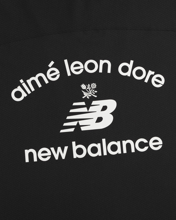 Black ALD / New Balance Full-Zip Warmup Hoodie with white arched text and small floral graphic on black fabric.