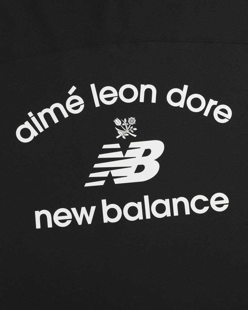 Black ALD / New Balance Full-Zip Warmup Hoodie with white arched text and small floral graphic on black fabric.