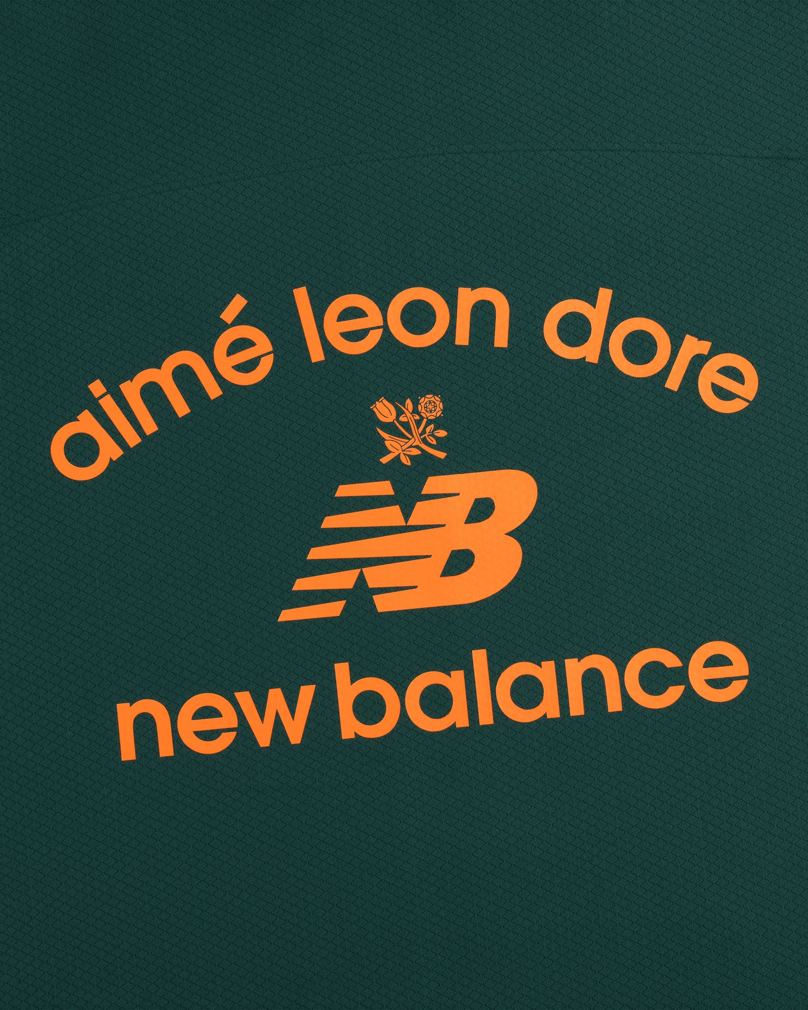 The ALD / New Balance Full-Zip Warmup Hoodie features orange logos on a dark green textured background.