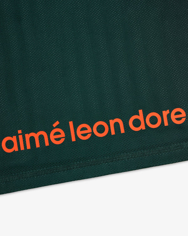 Close-up of dark green ALD / New Balance Running Gradient Singlet with bold orange aimé leon dore near the edge.
