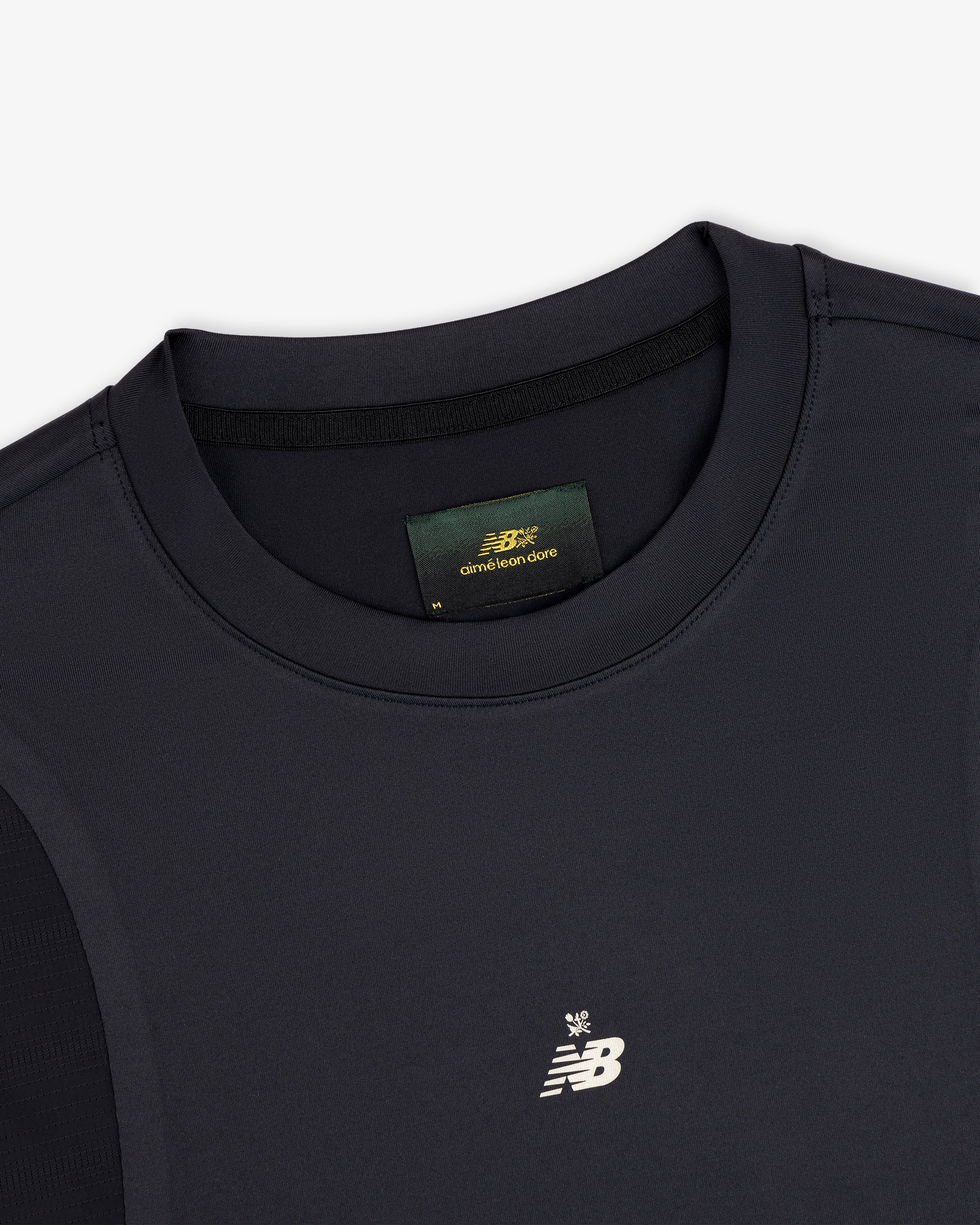 Close-up of a black ALD / New Balance Performance Long-Sleeve Tee with white logo and green label inside the collar.