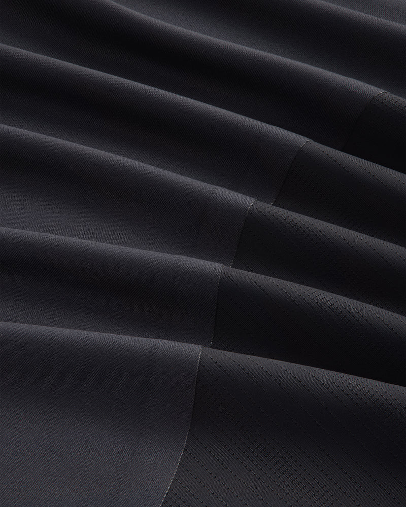 Close-up of the ALD / New Balance Performance Long-Sleeve Tee's dark, pleated fabric with matte and shiny textures.