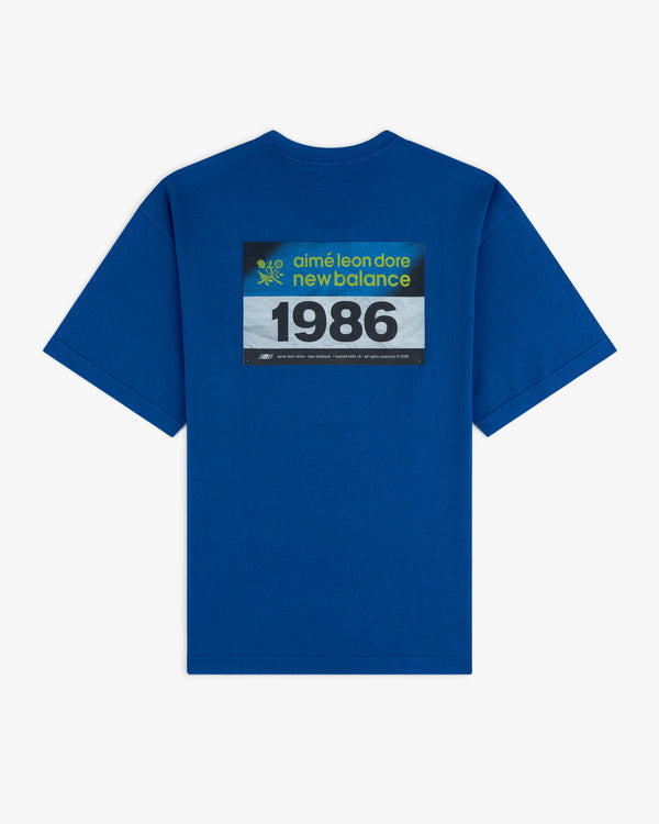 ALD / New Balance Running Bib Tee: Blue T-shirt with a black rectangular graphic on the back.