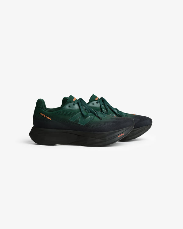 ALD / New Balance FuelCell SuperComp Elite v5 in dark green with black soles and orange accents on white background.