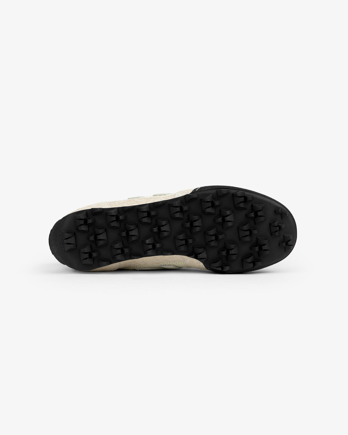 Bottom view of the ALD / New Balance Gator sneaker with a black rubber sole and triangular treads, on white.