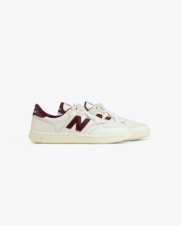ALD / New Balance T500 tennis sneaker in off-white with maroon accents and a cream rubber sole.
