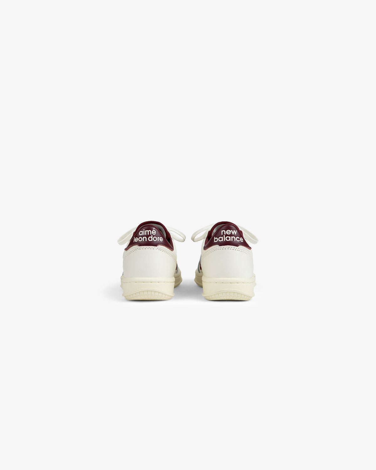 Back view of two off-white ALD / New Balance T500 Tennis Oxfords with dark red heel tabs featuring brand text.