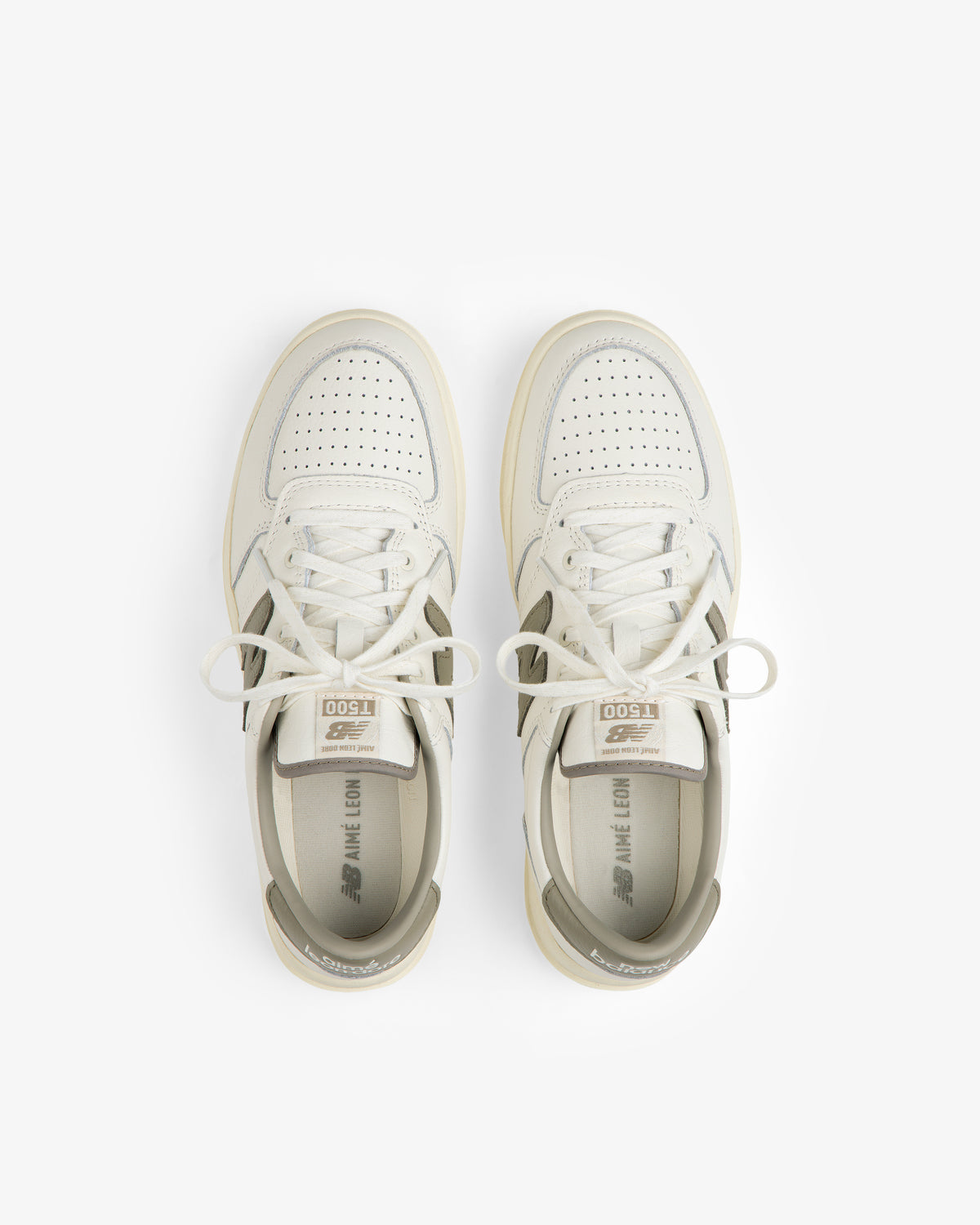 Top-down view of cream-colored ALD / New Balance T500 Tennis Oxfords with gray accents and perforated toes.