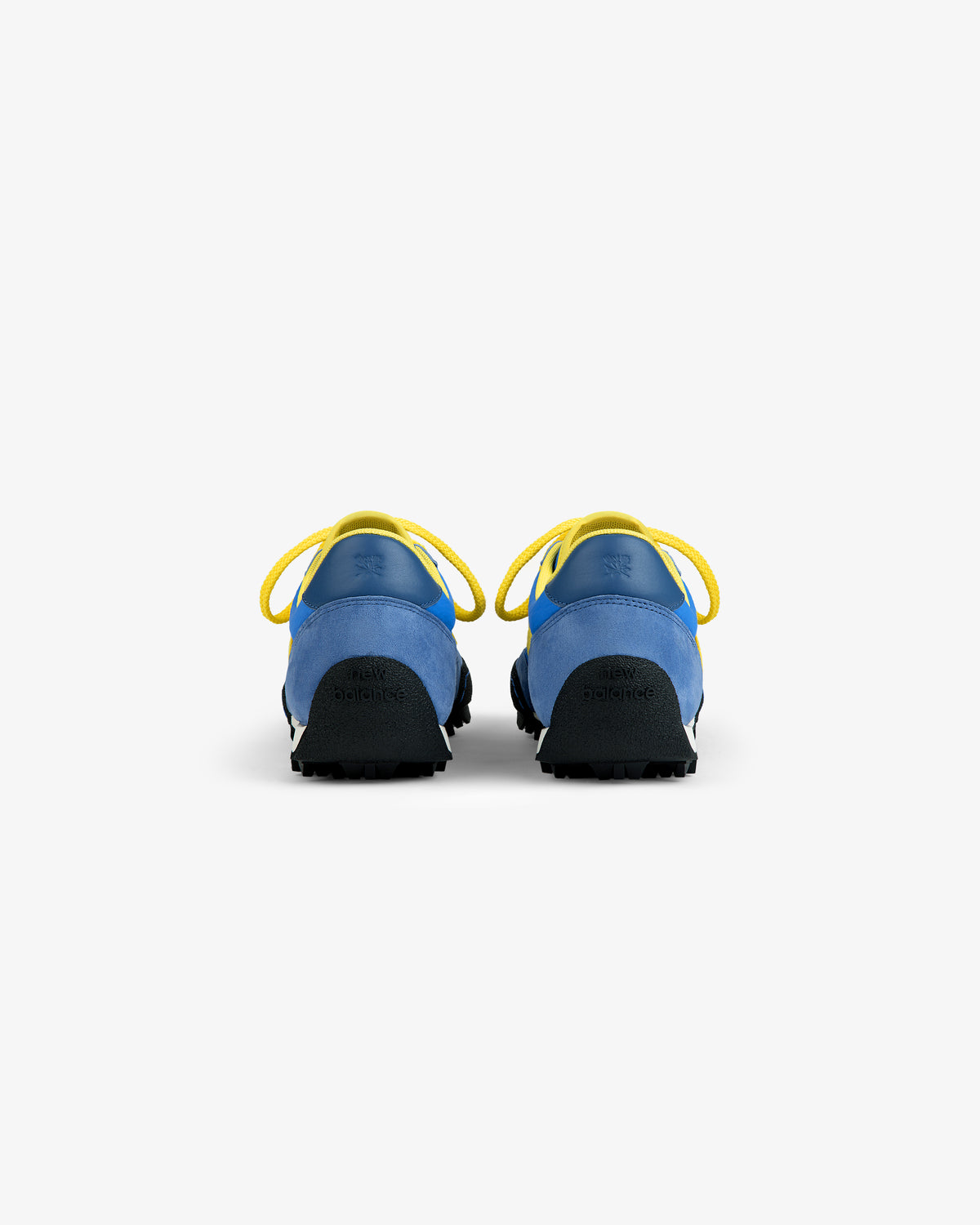 Back view of blue and yellow ALD / New Balance Gator athletic shoes with yellow laces and black lugged outsoles.