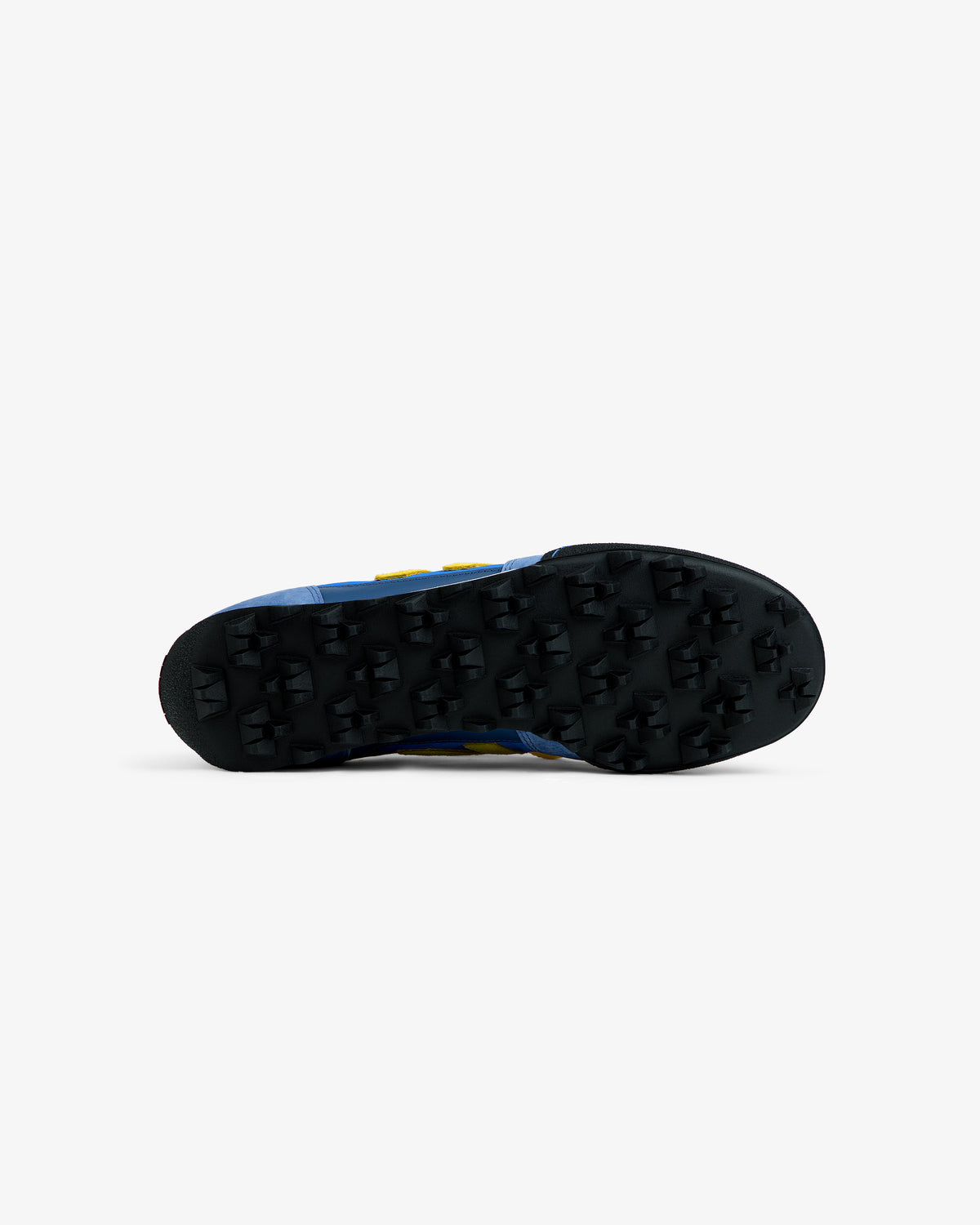 Black lugged rubber outsole of a blue ALD / New Balance Gator athletic shoe with yellow accents.