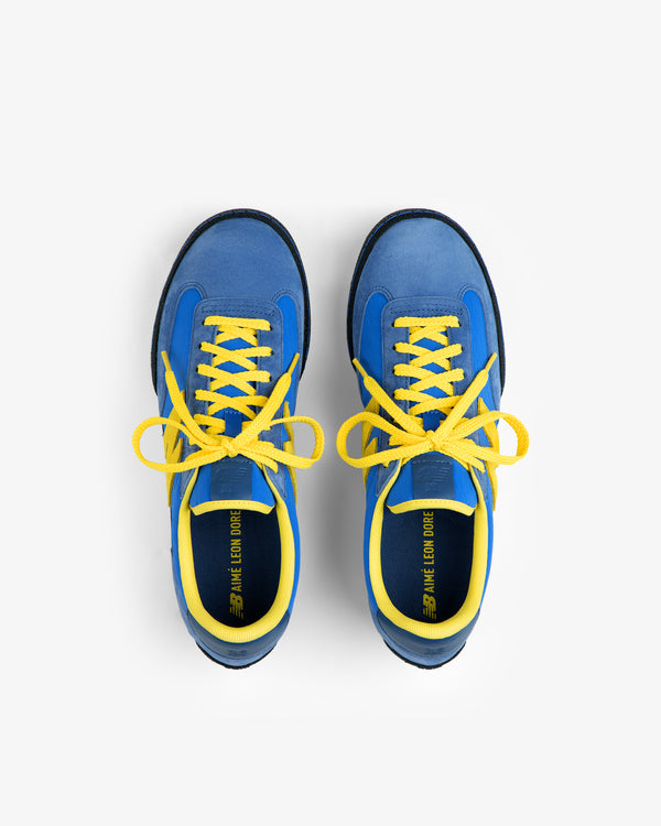 Pair of blue ALD / New Balance Gator sneakers with bright yellow laces and linings, viewed from directly above.