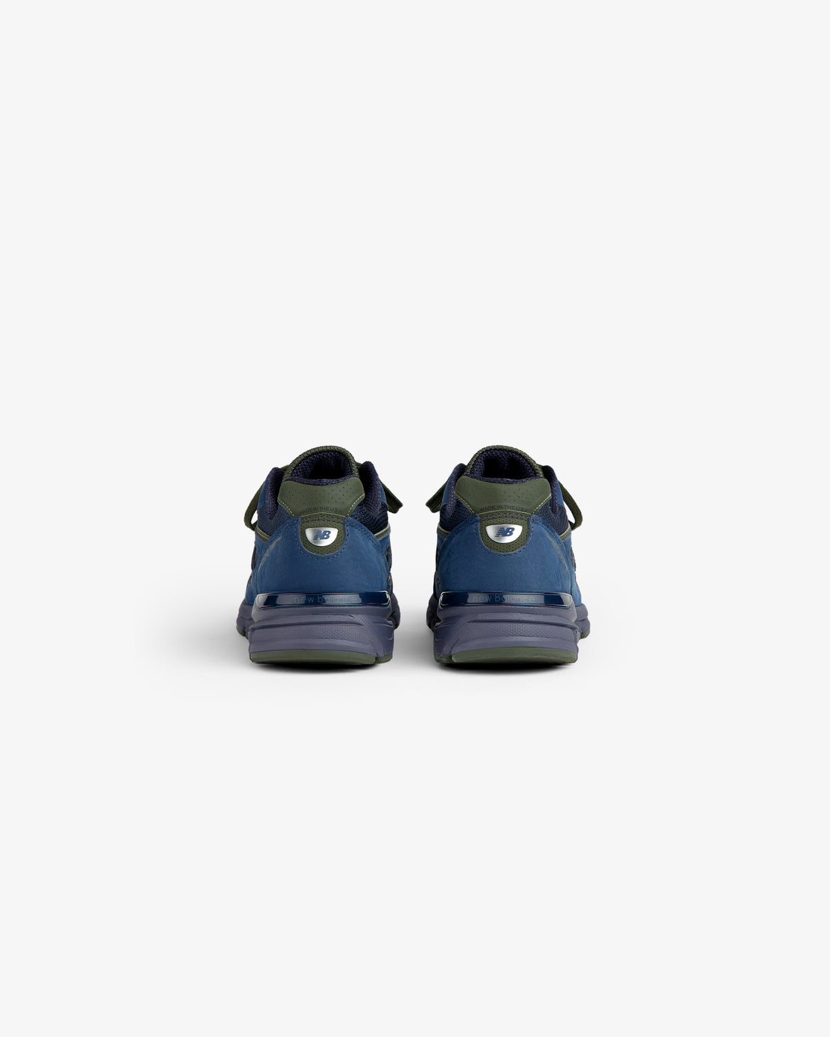 New Balance Made in USA 990v4 sneakers in blue and green, shown from the back on a white background.