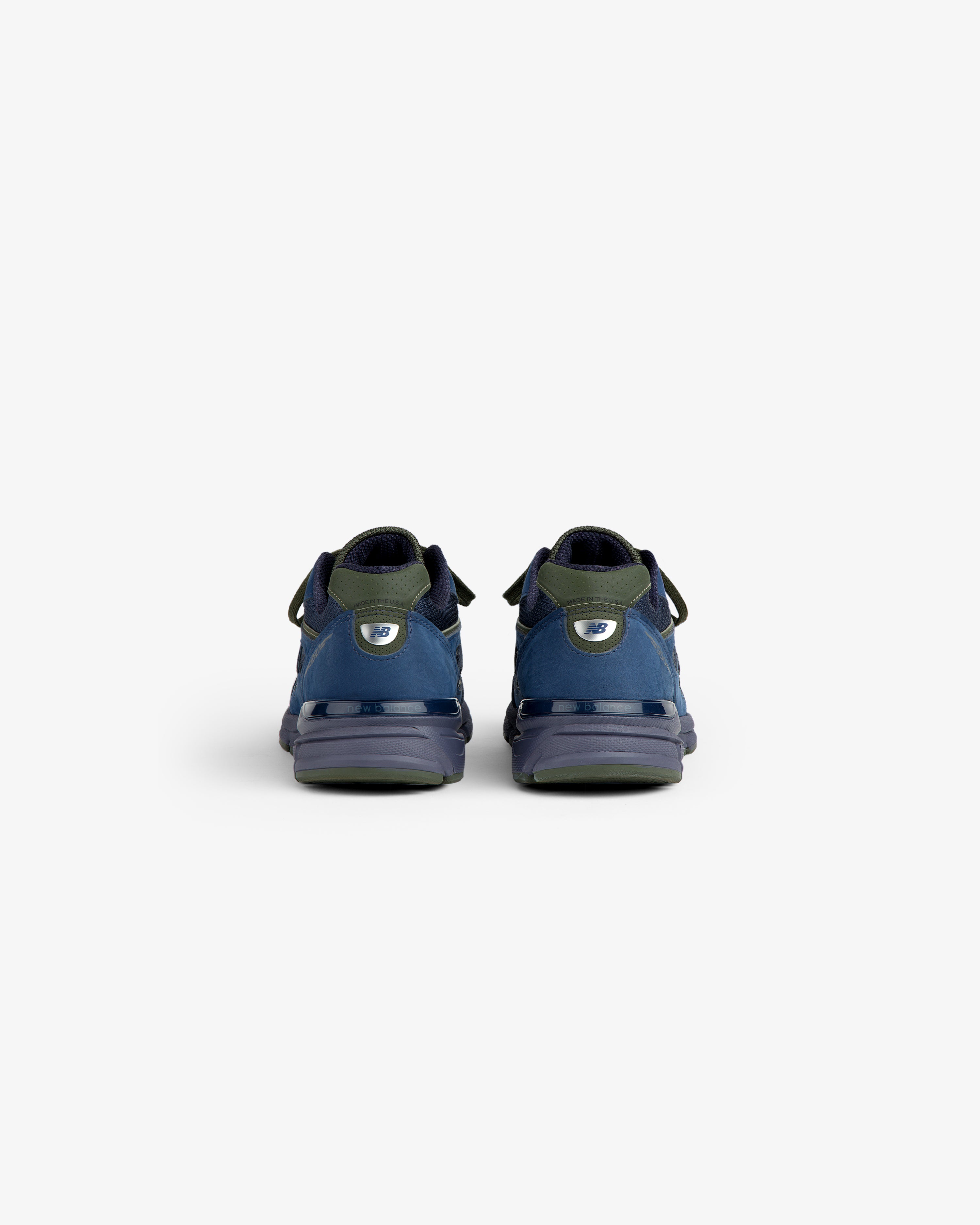 New Balance Made in USA 990v4 sneakers in blue and green, shown from the back on a white background.