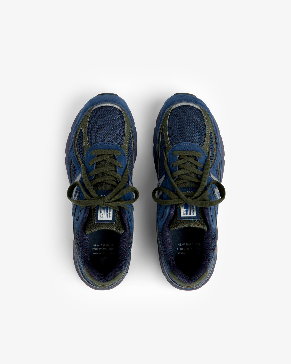 New Balance Made in USA 990v4 sneakers in dark blue with green laces, top view on a white background.