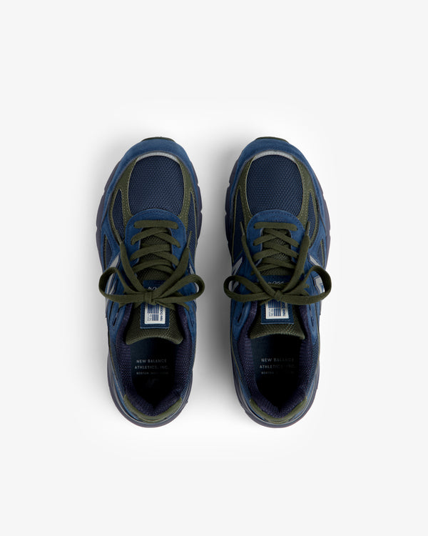New Balance Made in USA 990v4 sneakers in dark blue with green laces, top view on a white background.