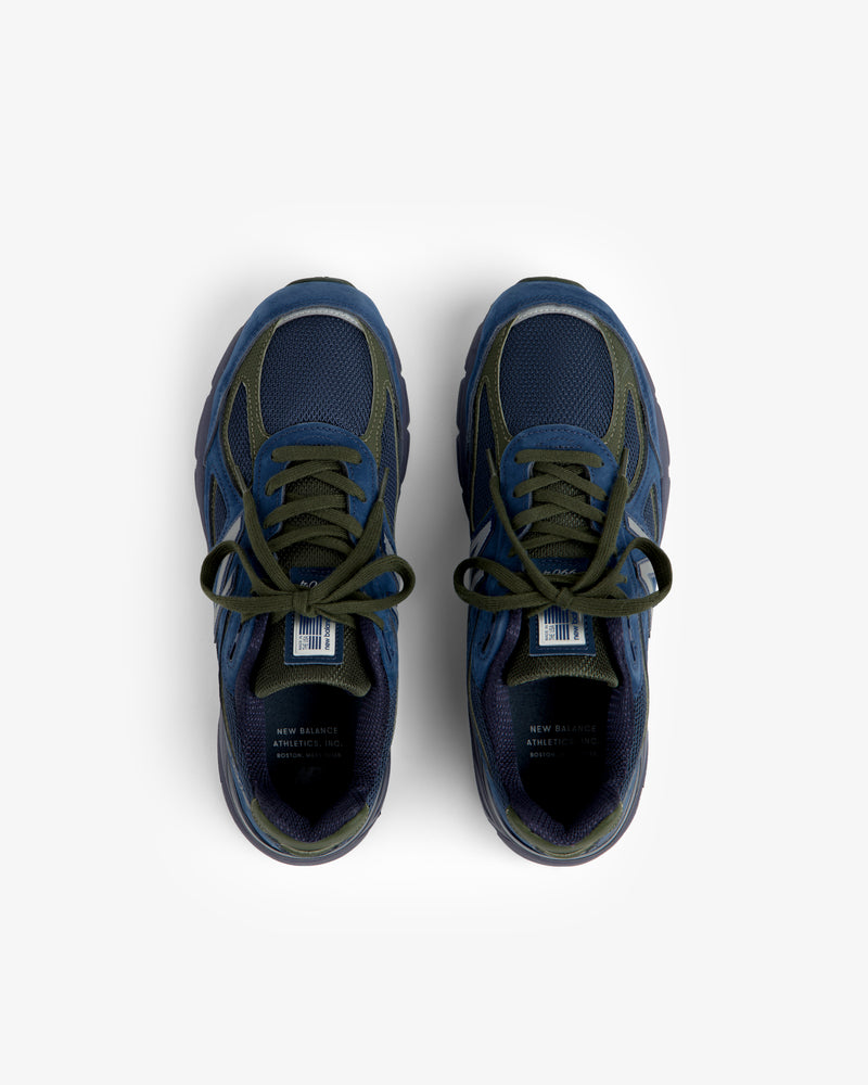 New Balance Made in USA 990v4 sneakers in dark blue with green laces, top view on a white background.