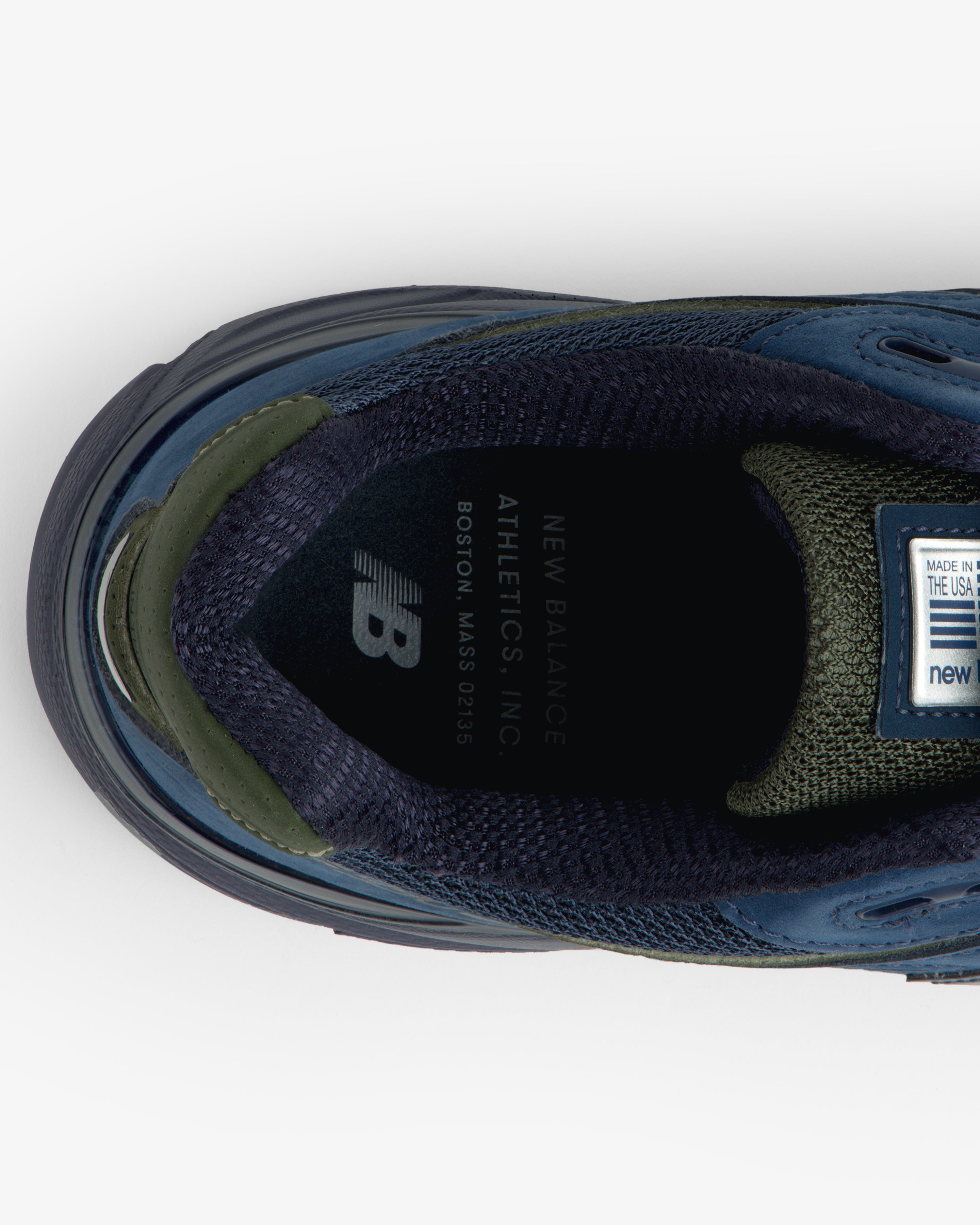 Top view of New Balance Made in USA 990v4 sneaker in blue/green, showing insole branding and label details.