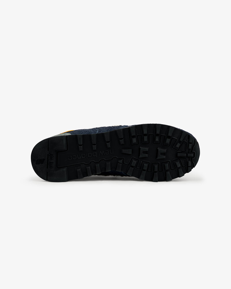 The black rubber sole of the ALD / New Balance Made in USA 1300 sneaker is shown from the bottom on a white background.