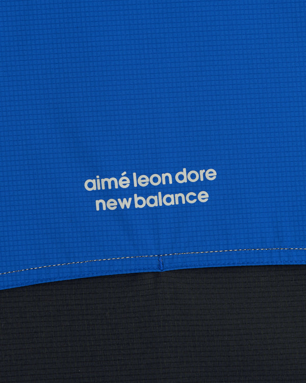 Close-up of blue ALD / New Balance Performance Nylon Jacket with white logo in lowercase letters.