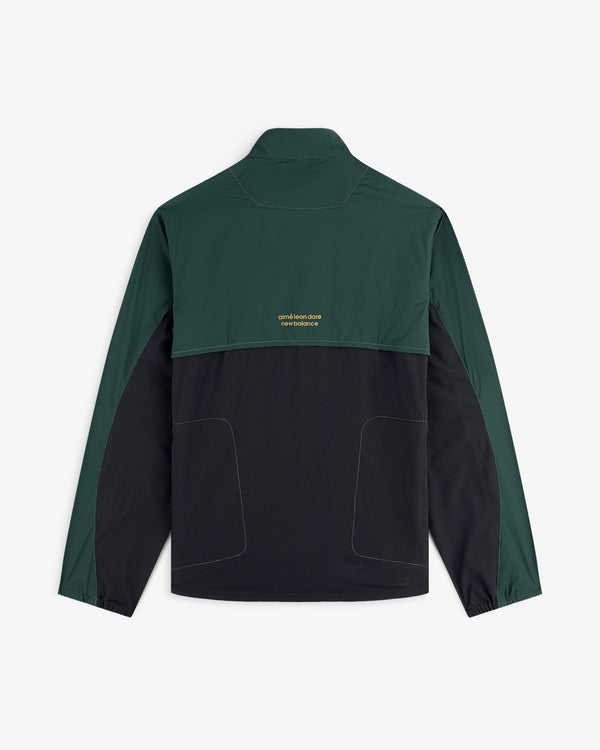 ALD / New Balance Performance Nylon Jacket with dark green sleeves/top, black bottom, and small yellow text on the back.