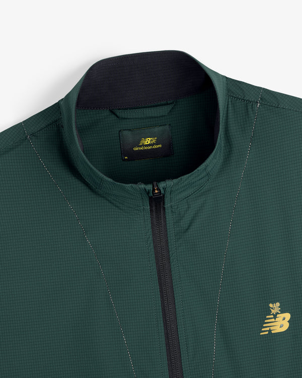 Close-up of the ALD / New Balance Performance Nylon Jacket in green with zip front and gold chest logo.
