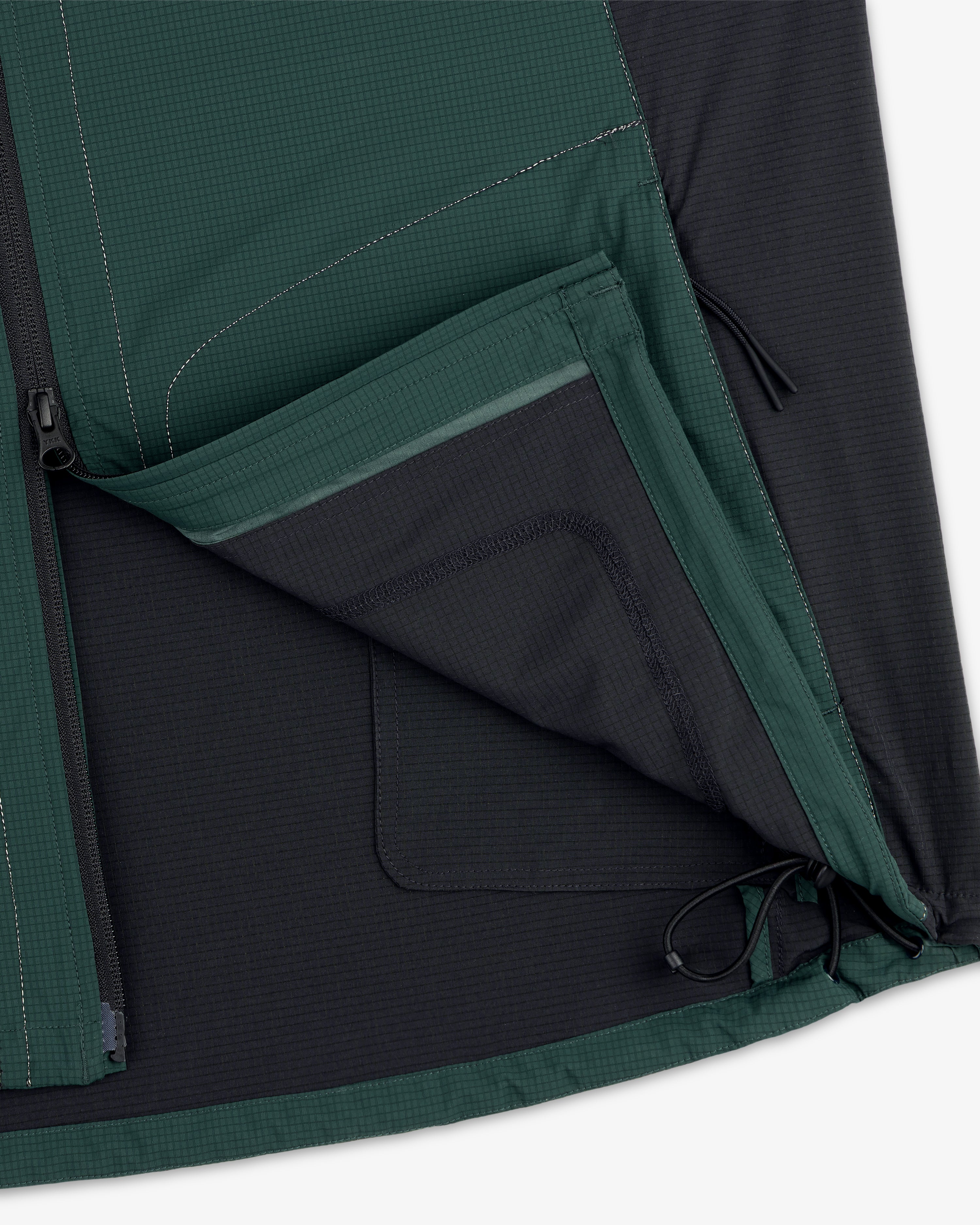 Close-up of the ALD / New Balance Performance Nylon Jacket with open zippered pocket, mesh lining, and visible stitching.