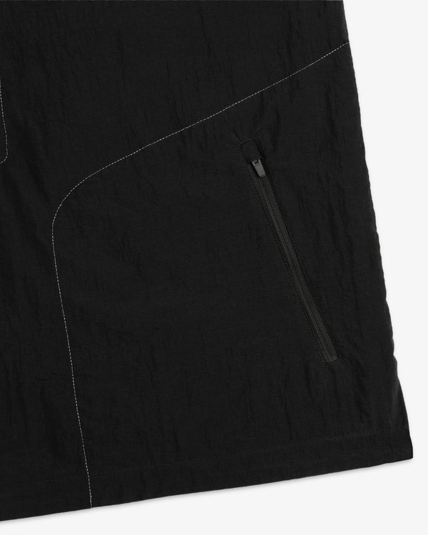 Close-up of the ALD / New Balance Breathable Half-Zip Pullover in black with white stitching and diagonal zip pocket.