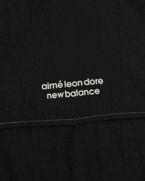 Close-up of black ALD / New Balance Breathable Half-Zip Pullover with white logo above a stitched seam.