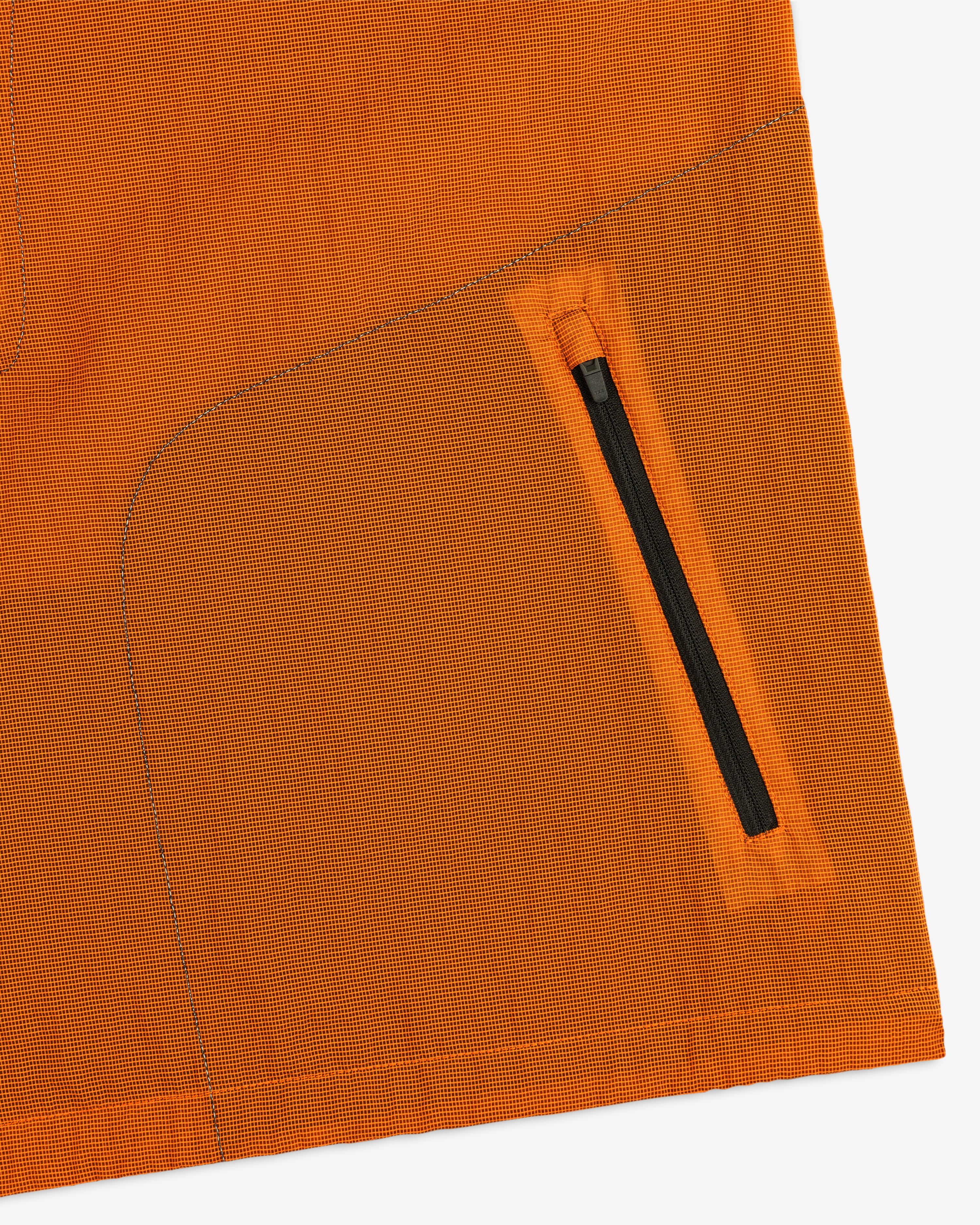 Close-up of the ALD / New Balance Breathable Half-Zip Pullover’s orange fabric, black zipper pocket, and detailed stitching.