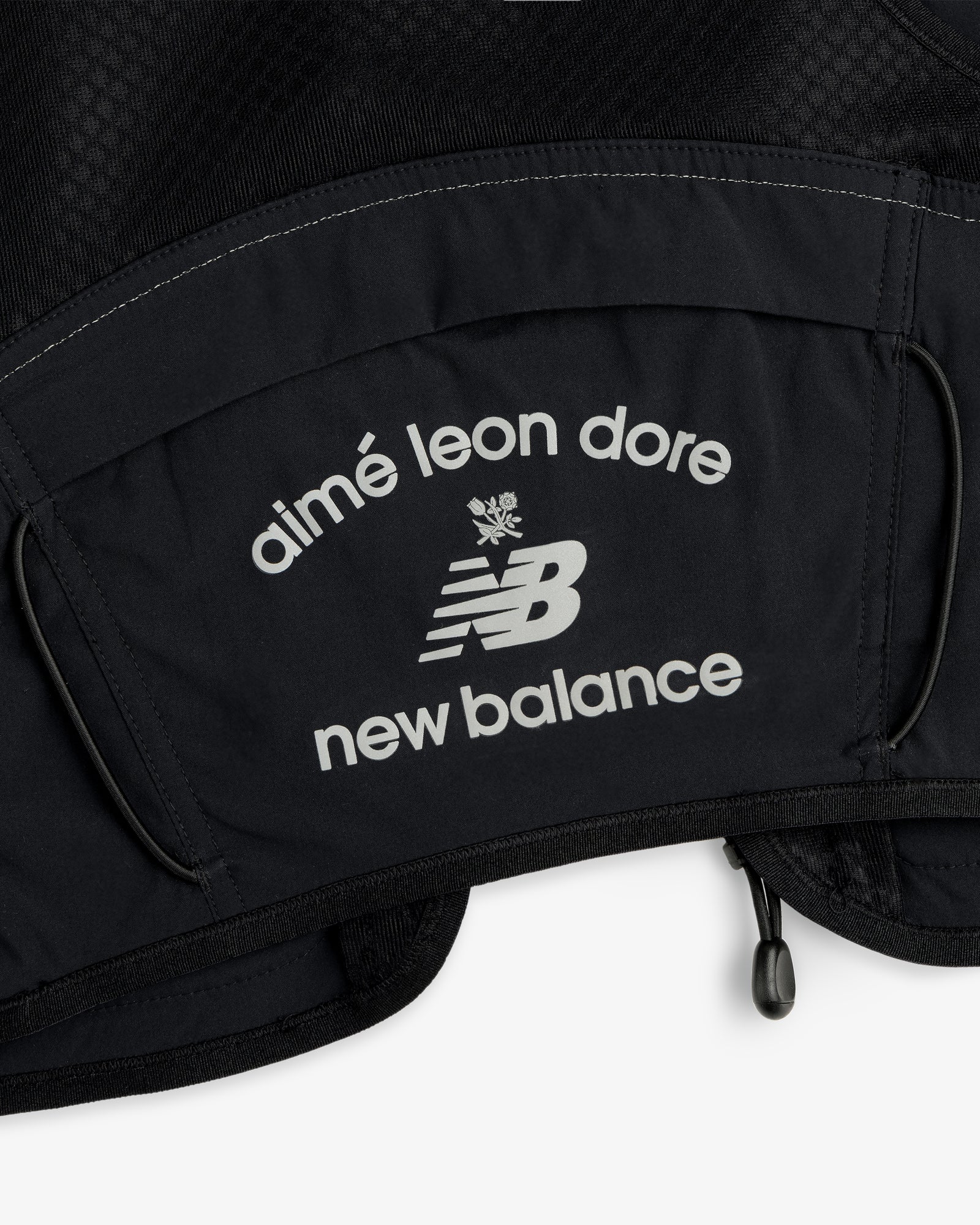 Close-up of the ALD / New Balance Hydrovest's black fabric with white aimé leon dore and NB logos.