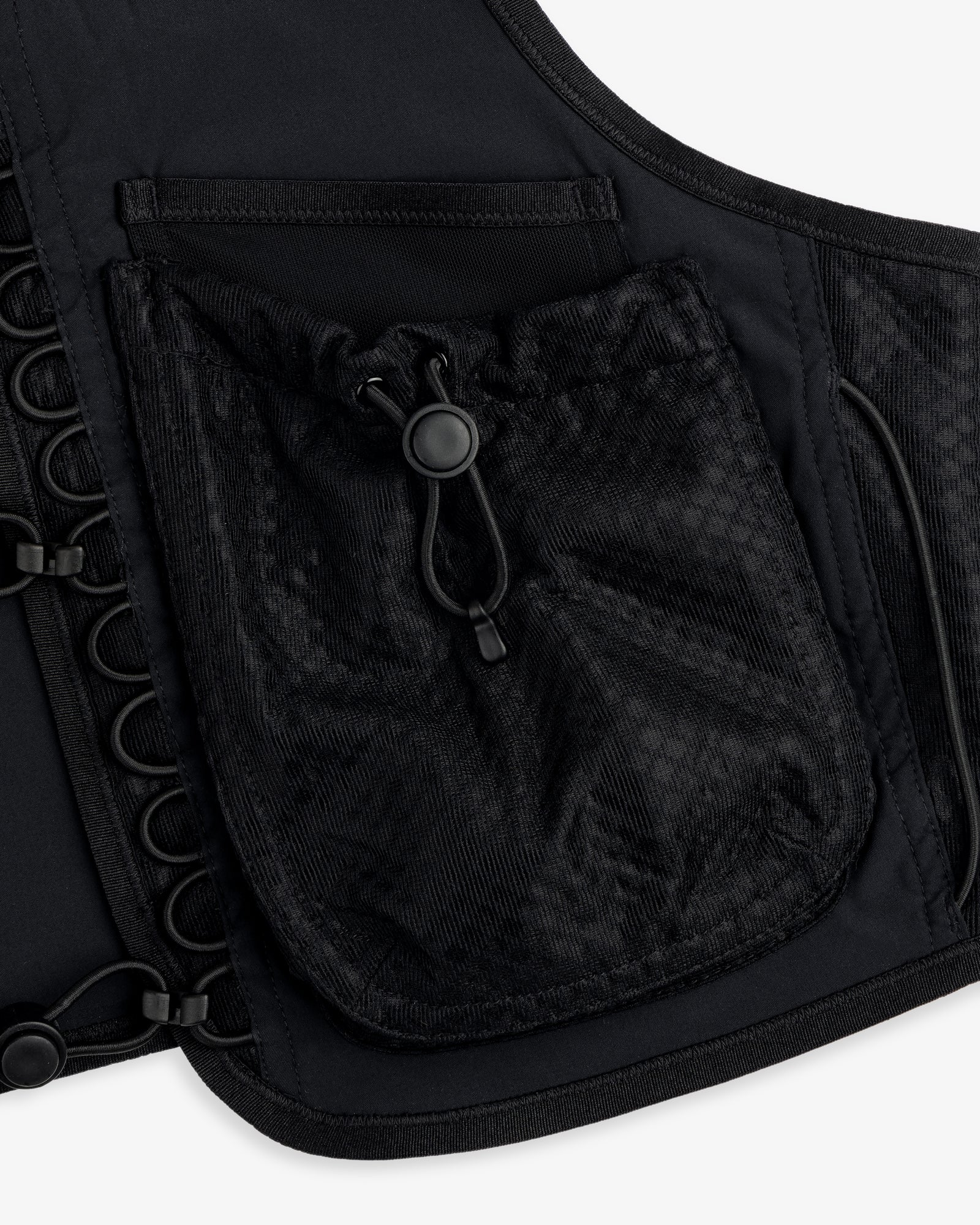 Close-up of the ALD / New Balance Hydrovest, a black vest with a mesh pocket, drawstring, and grommet details.