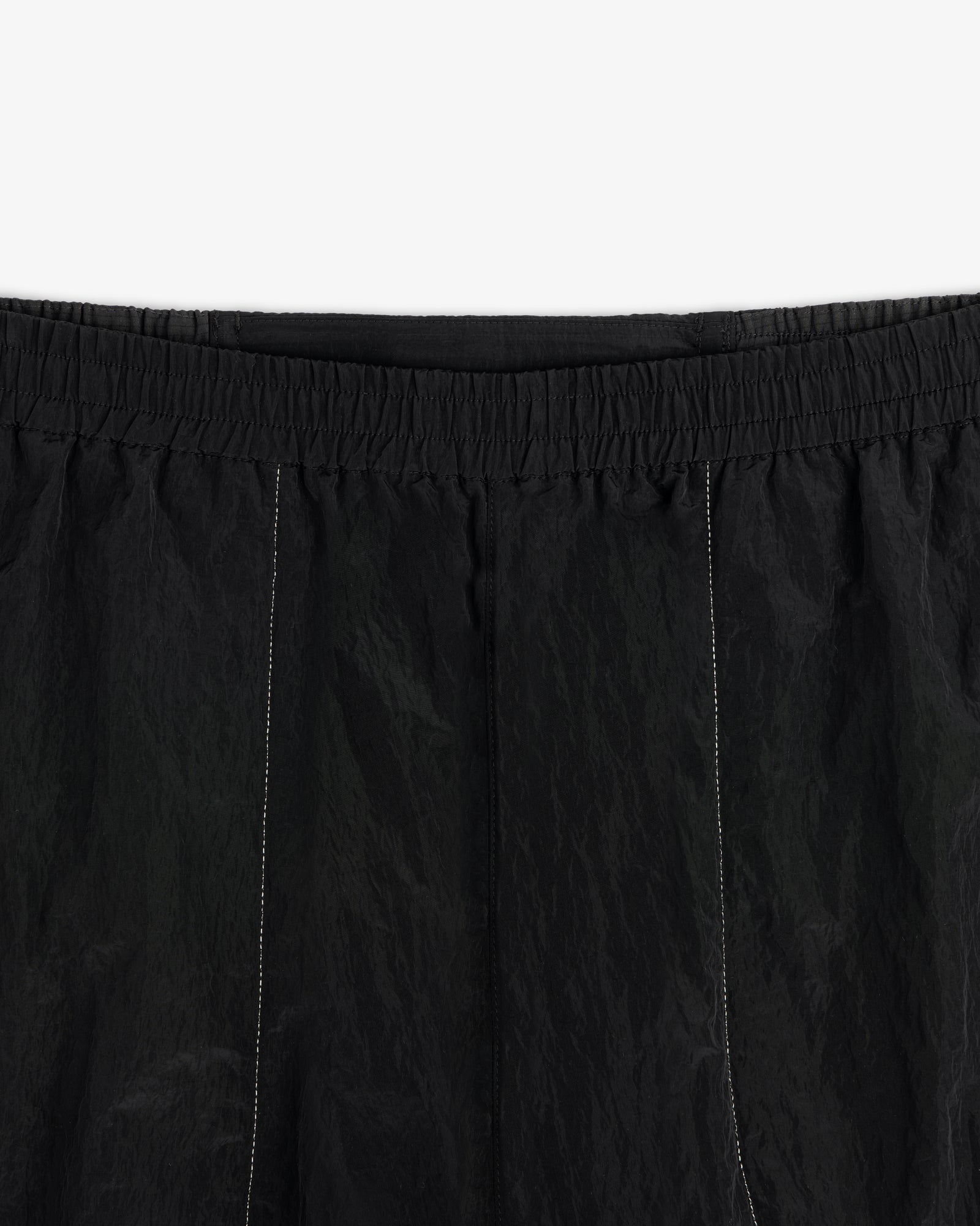 Close-up of ALD / New Balance Lightweight Nylon Warmup Pant with elastic waistband and subtle vertical stitching.